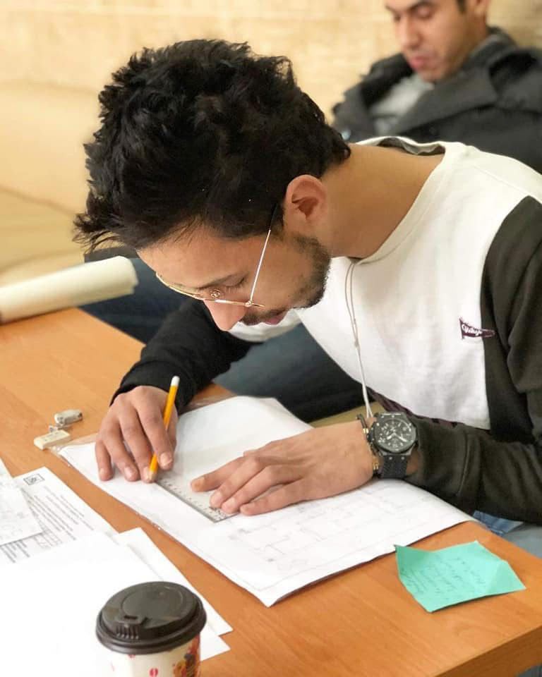Mehdi Annouch dessinant un plan à la main